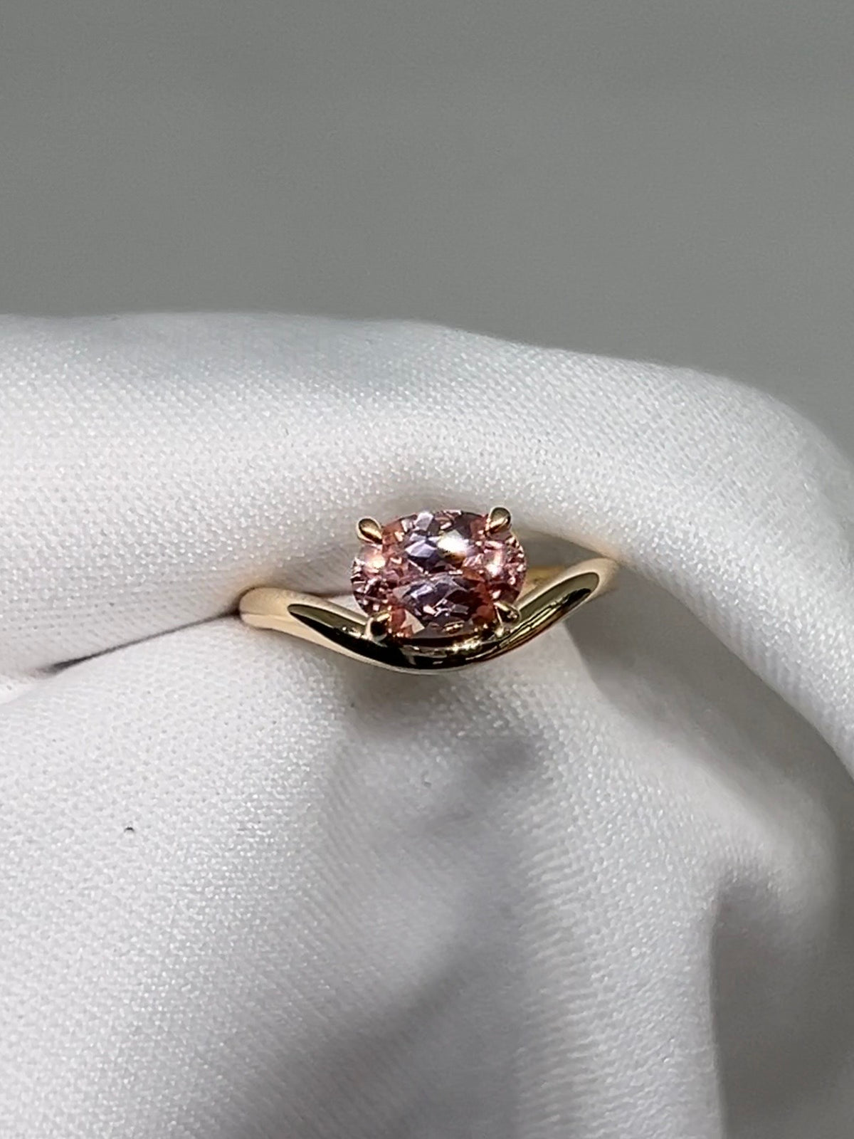 14k & 18k Gold ring with a pink gemstone on a curved band set in prongs