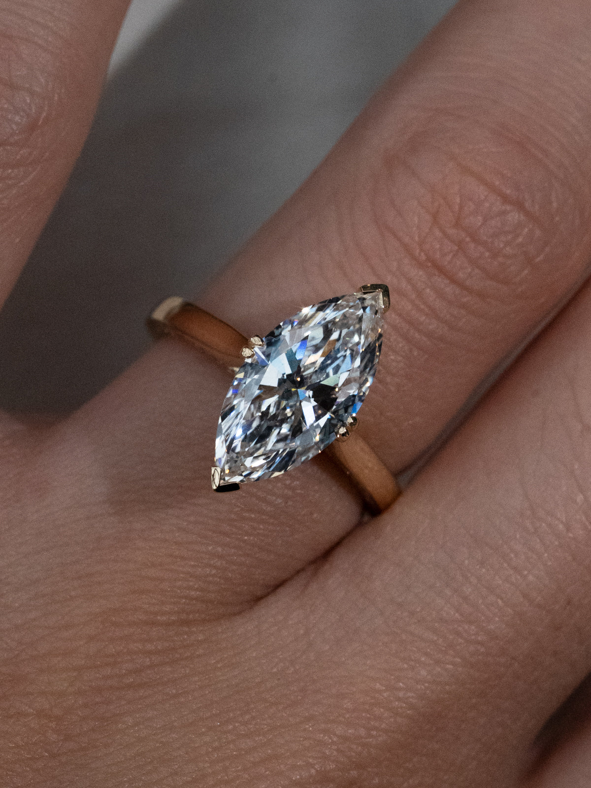 Front view of custom marquise cut diamond engagement ring with hidden halo and V-tip double claw prongs