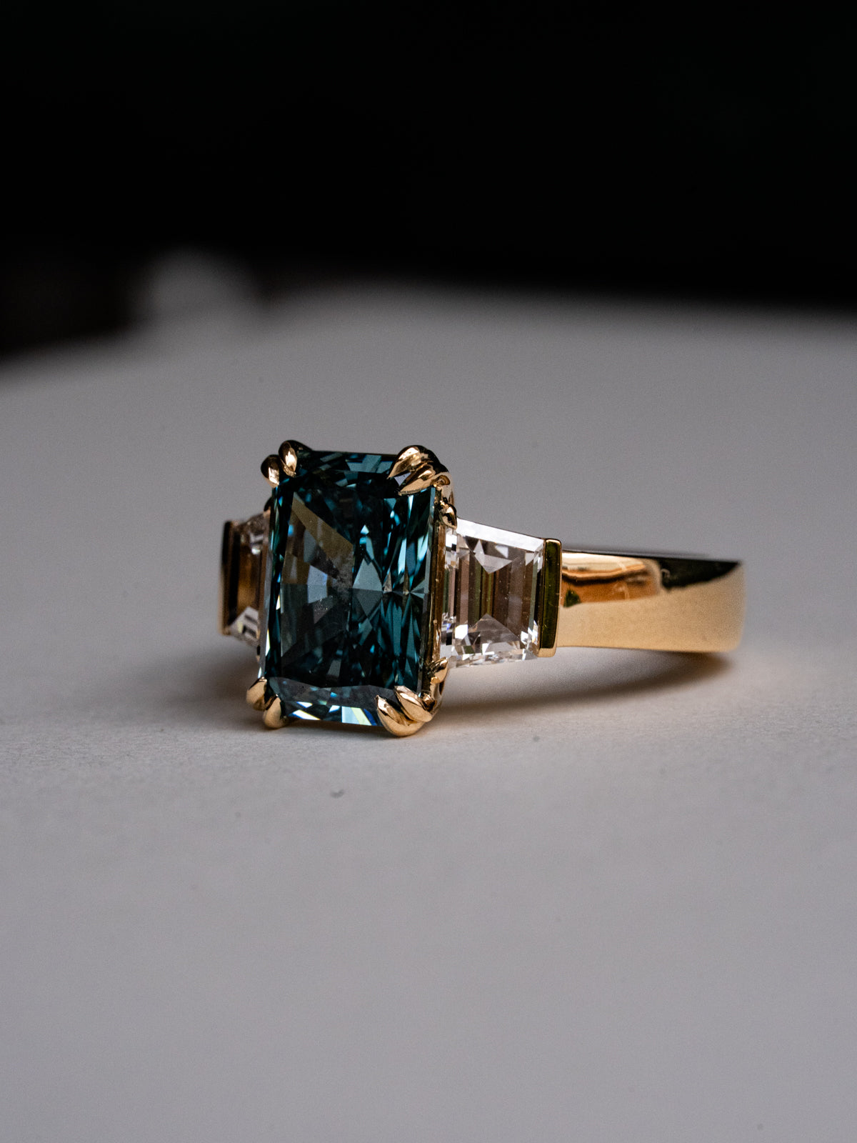 Gold ring with a blue gemstone on a gray background