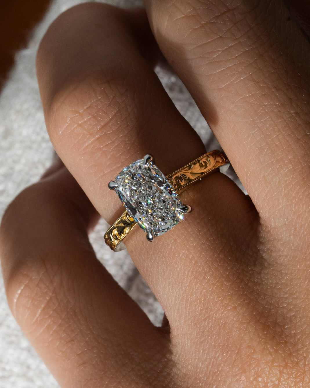 Close up o hand wearing a vintage engraved engagement ring